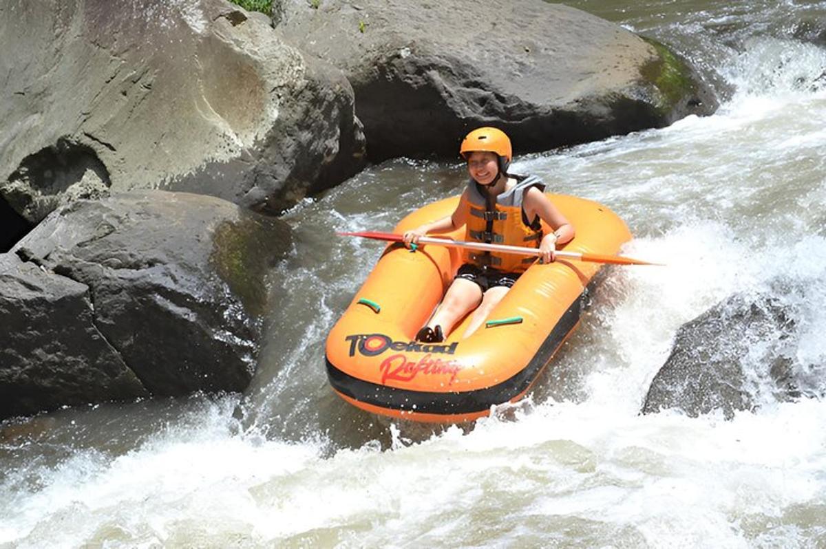 a man in an orange raft in a river