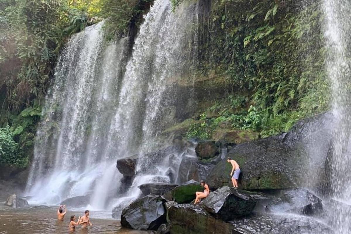 um grupo de pessoas na água de uma cachoeira