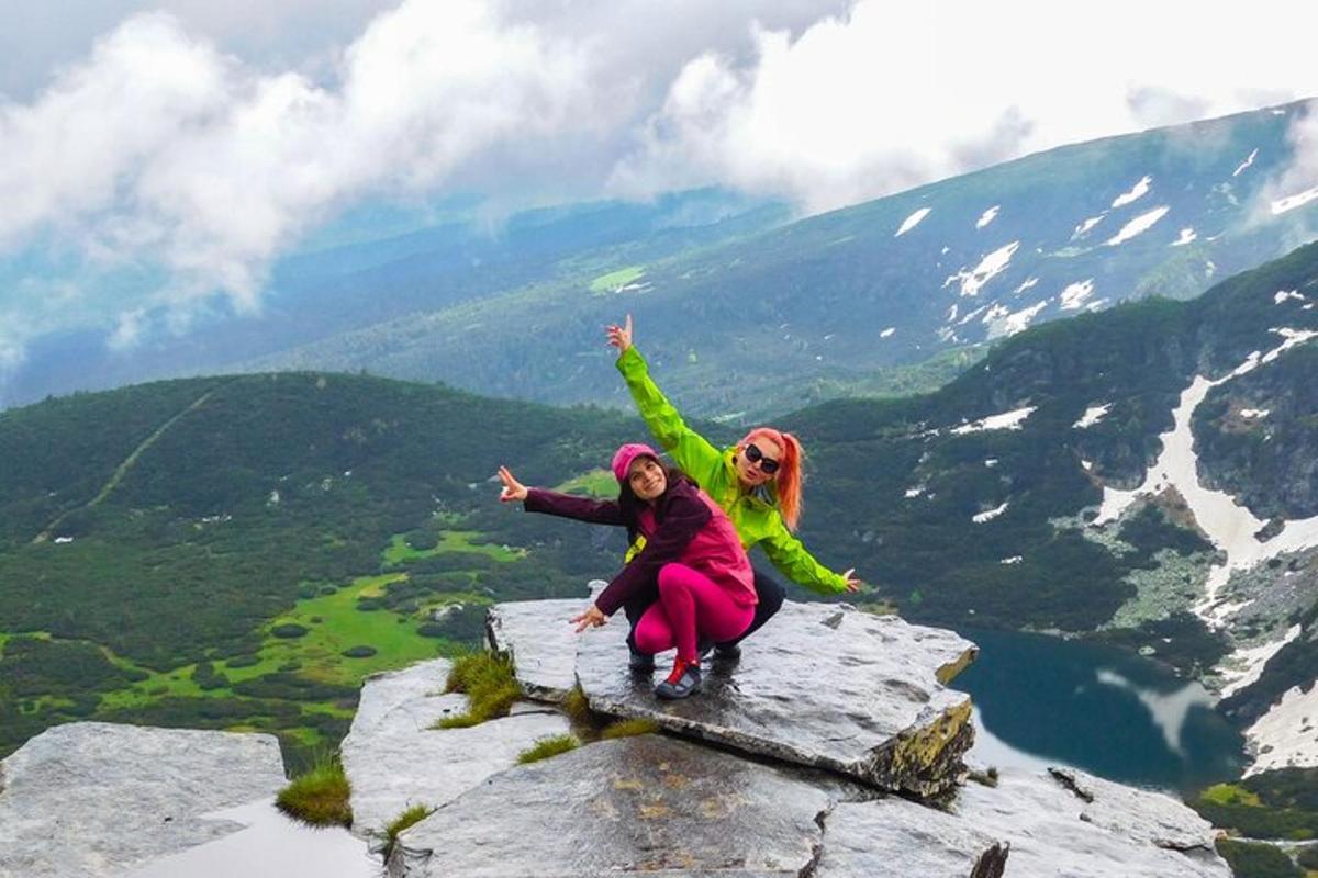 two women sitting on top of a mountain