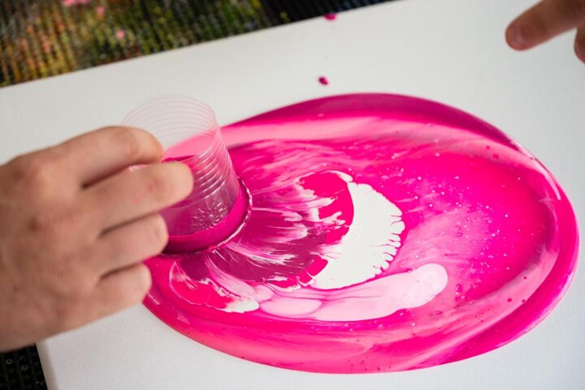 una persona che tiene in mano un dipinto rosa con un pennello