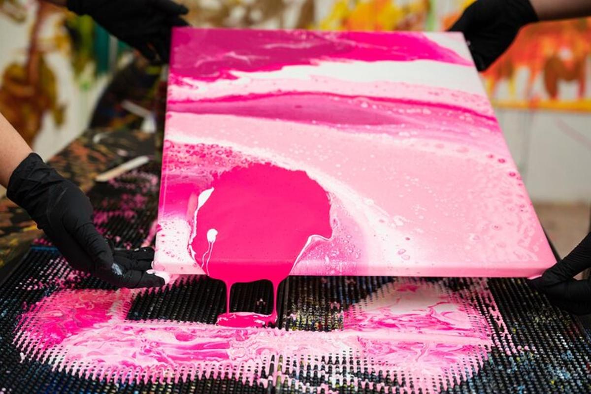 una persona che tiene in mano una torta rosa e bianca