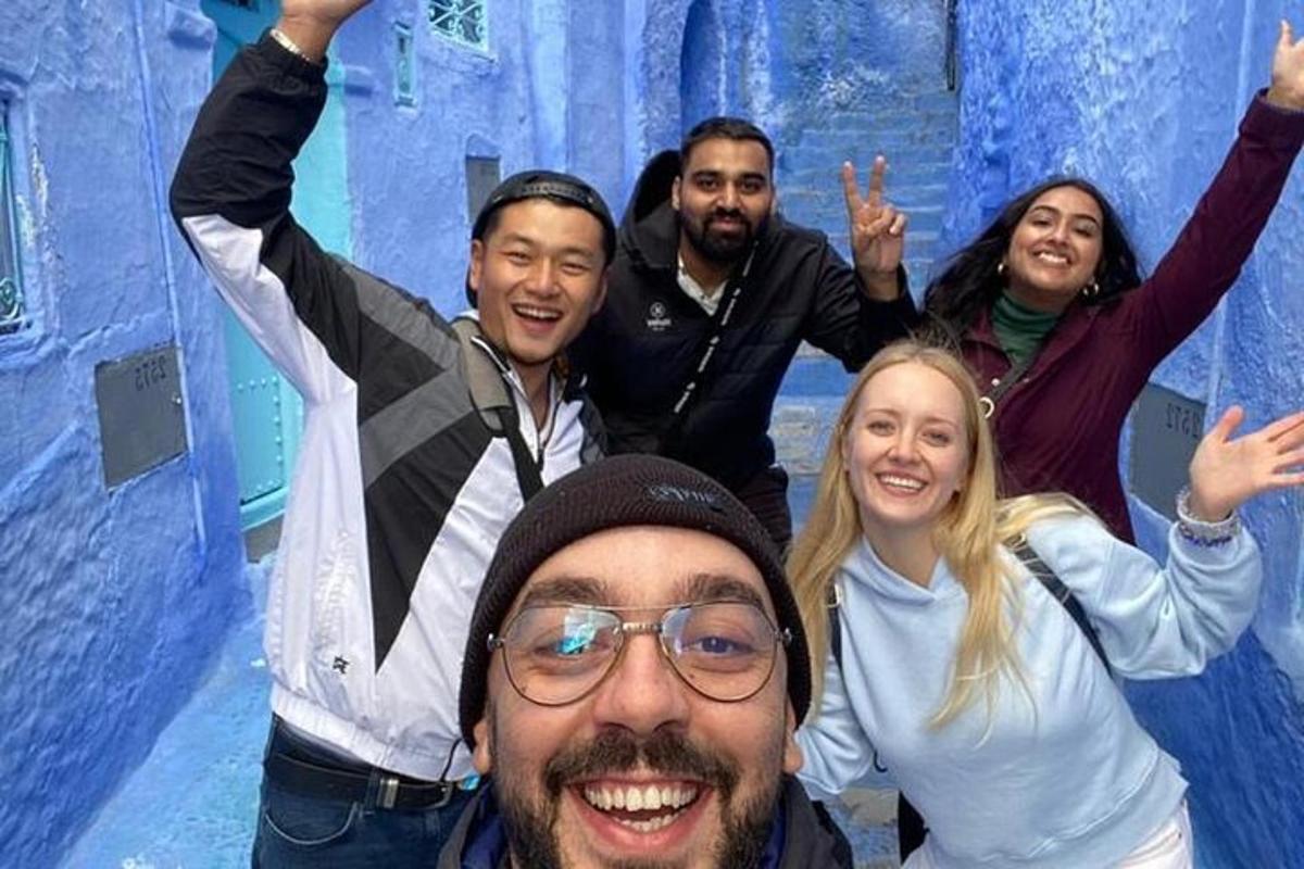 een groep mensen die voor een blauwe muur staan