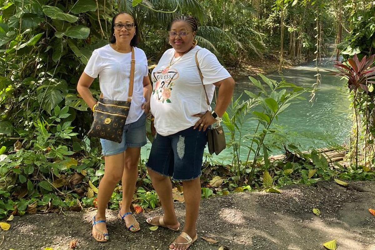 duas mulheres em pé uma ao lado da outra em frente a um rio