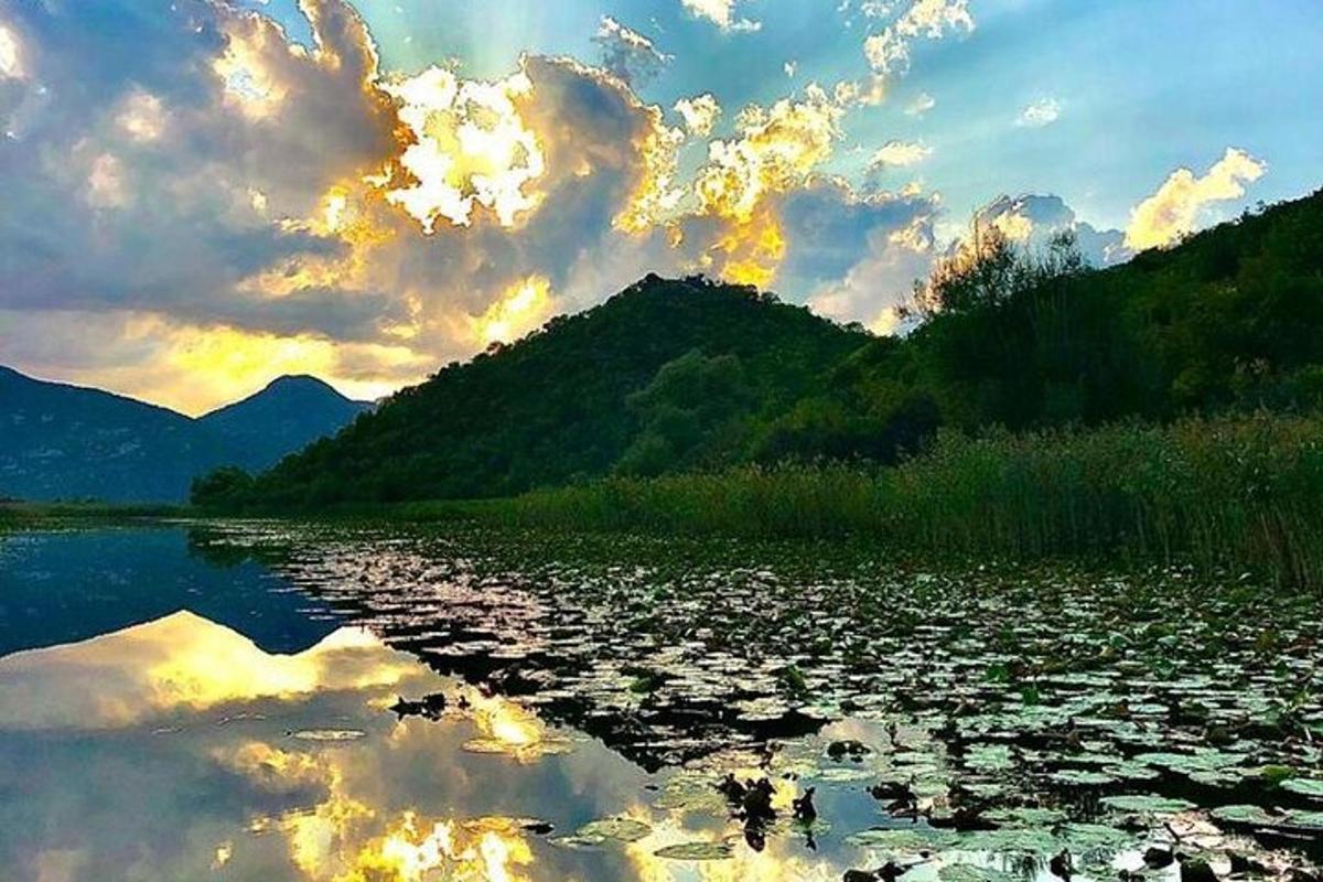 una gran massa d'aigua amb una posta de sol al fons