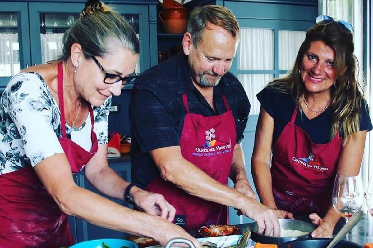 un uomo e due donne in una cucina che preparano il cibo