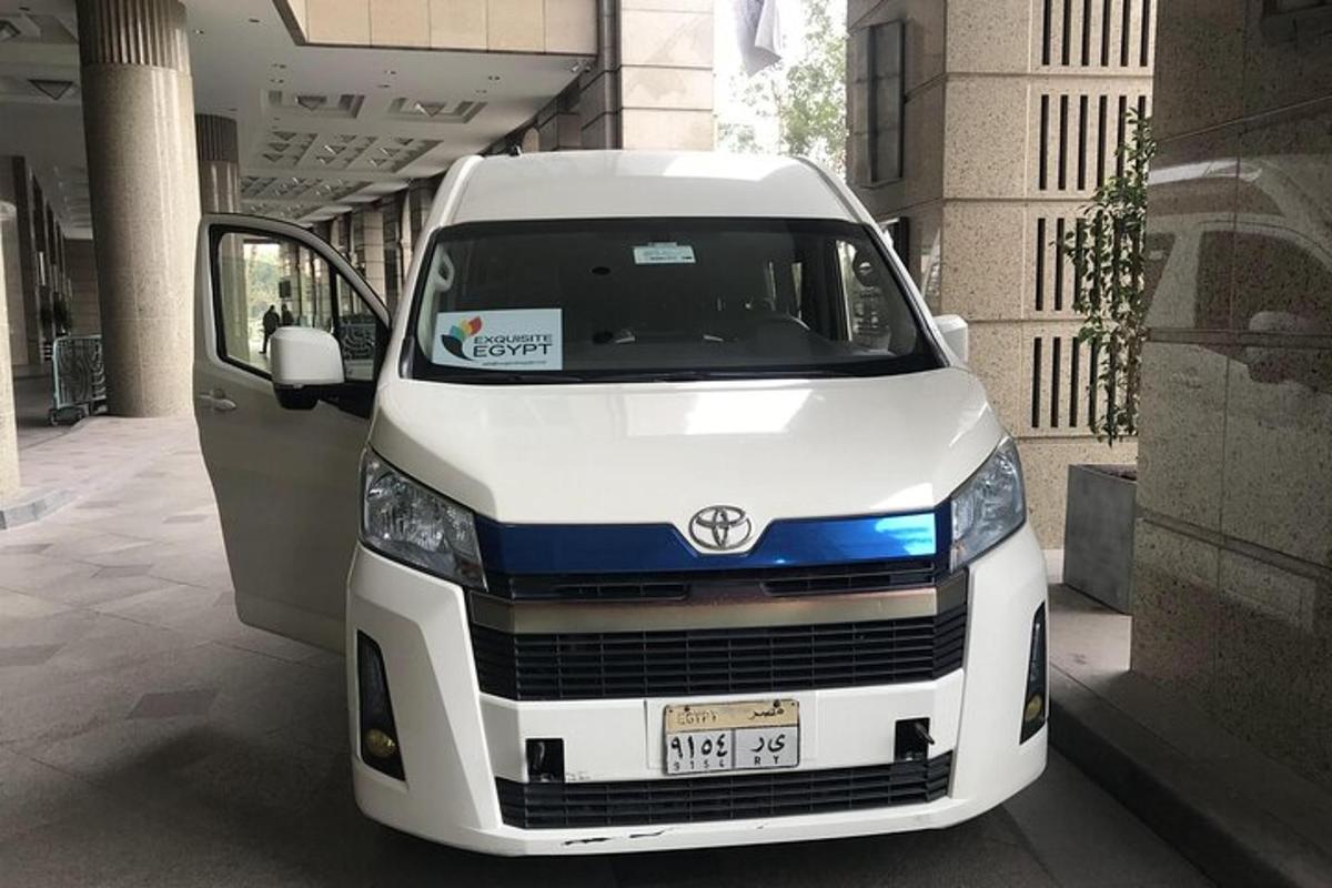 sebuah mobil van putih terparkir di samping pintu