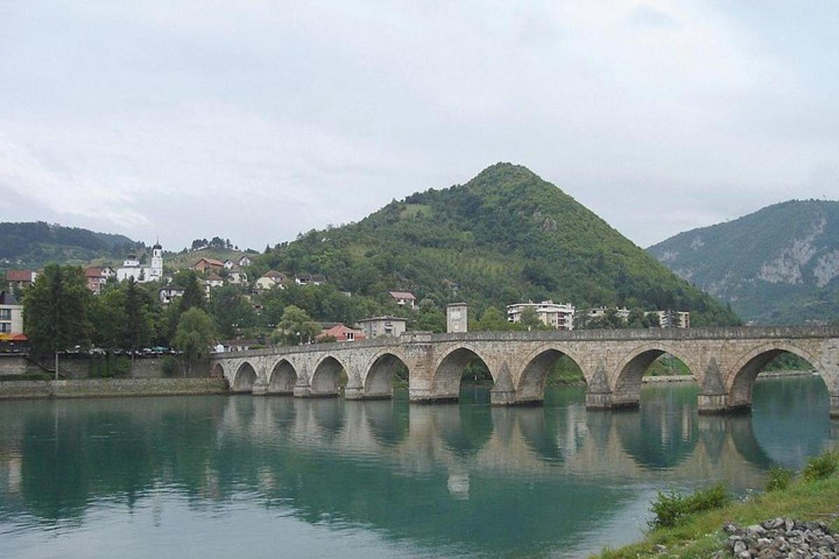 un ponte sopra un fiume con le montagne sullo sfondo