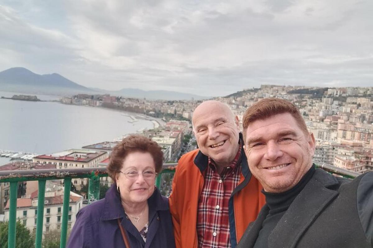 um grupo de três pessoas em pé no topo de uma cidade