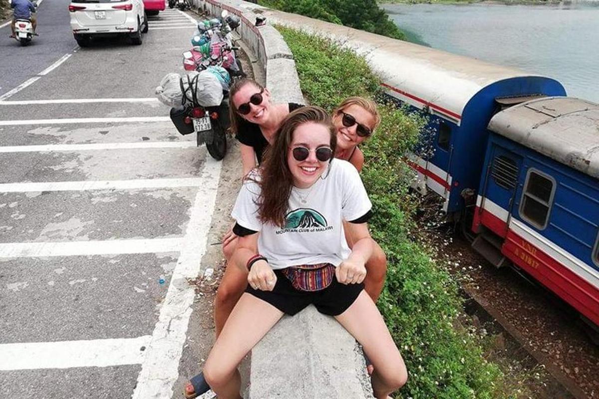 tři lidé sedící na zdi vedle vlaku