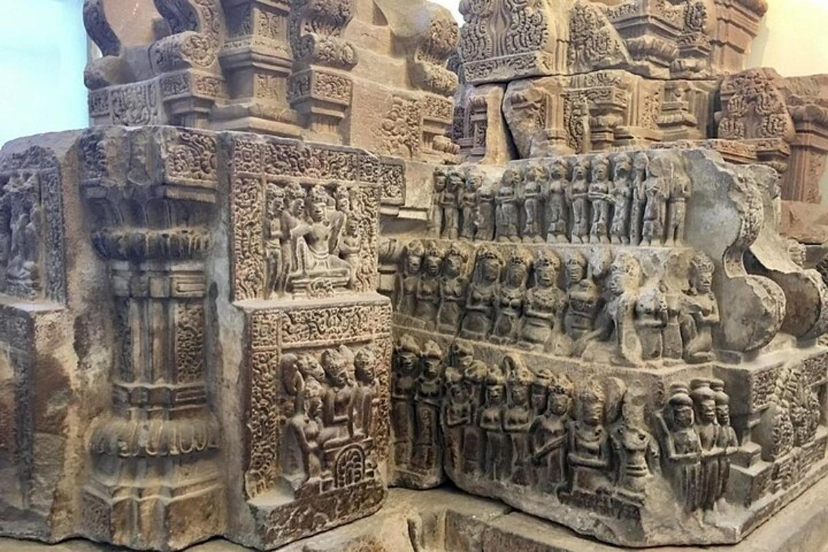 una escultura de pedra d'un edifici amb gent a sobre