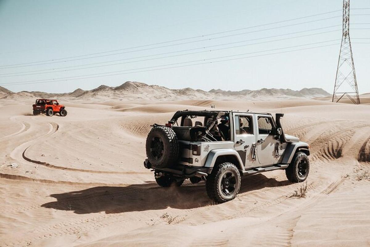 Dos jeeps conduciendo por la arena del desierto