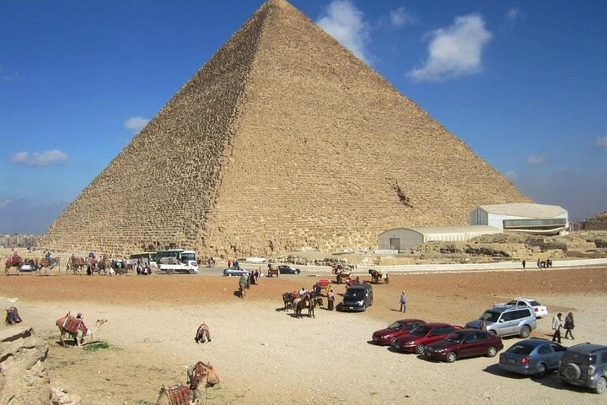 un gruppo di auto parcheggiate davanti a una piramide