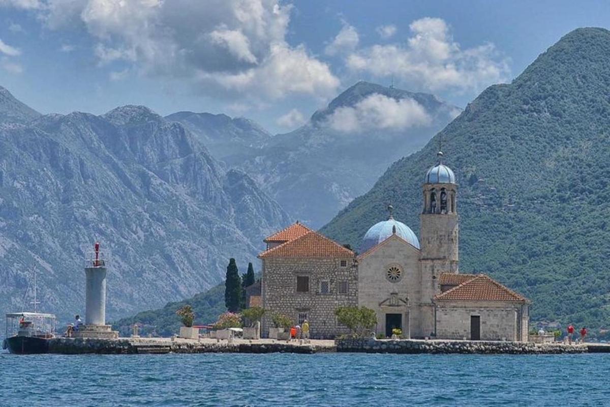 eine Kirche auf einer Insel im Wasser mit Bergen