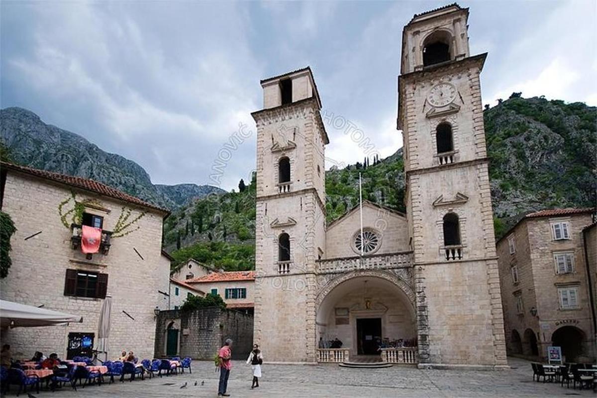 eine Kirche mit zwei Türmen, vor denen Menschen stehen