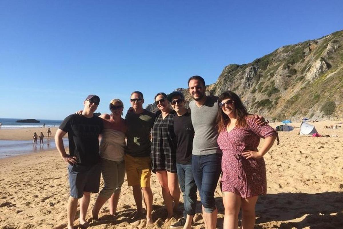een groep mensen die op het strand staat