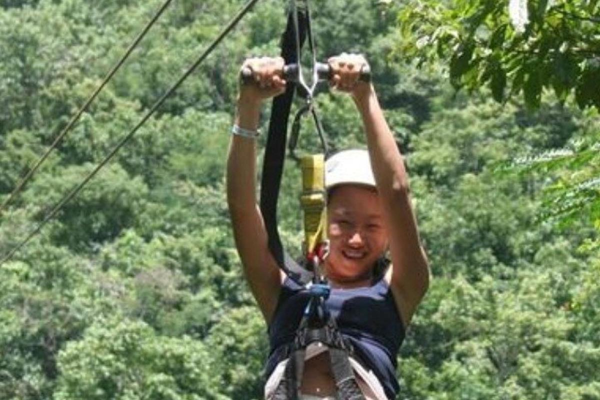 a woman on a zip line in the jungle