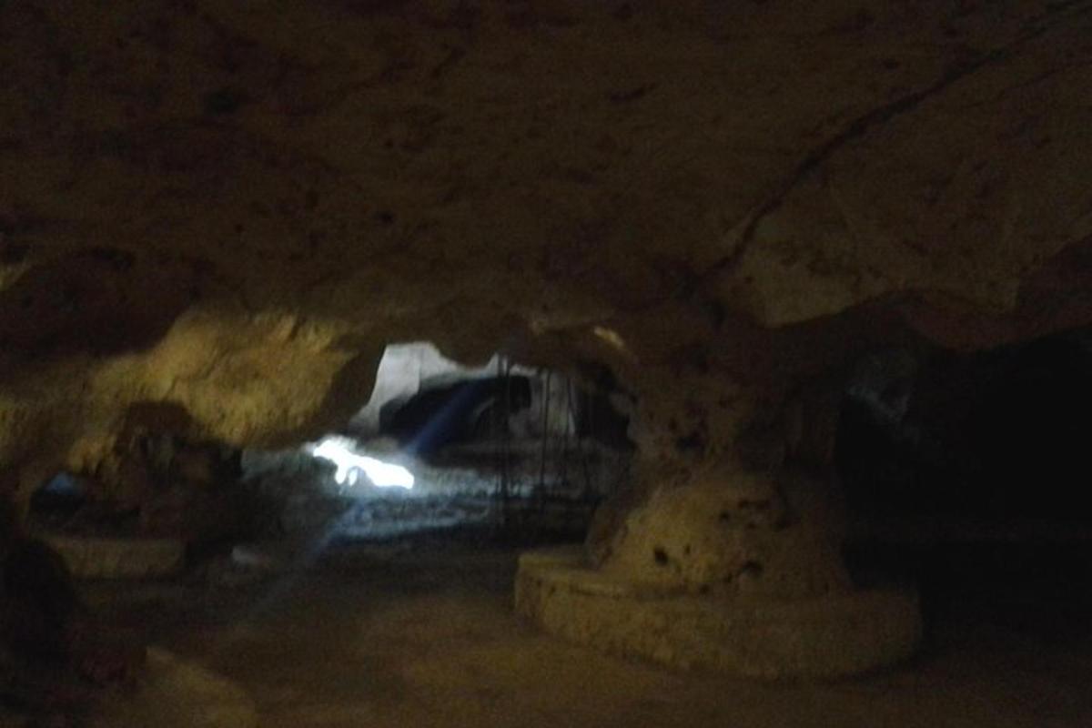 uma caverna escura com uma luz ao fundo