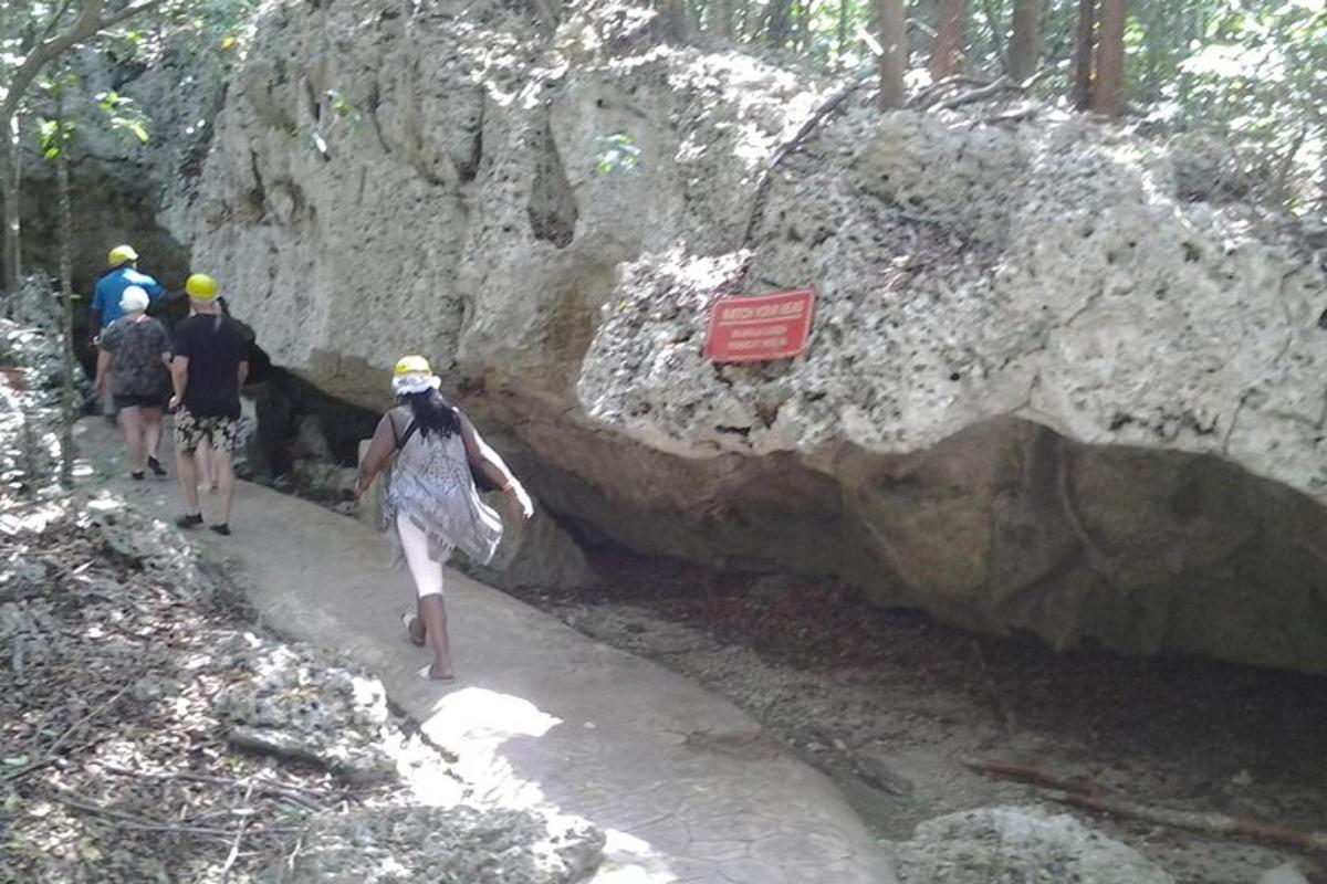 sekumpulan orang berjalan di atas laluan di sebelah batu