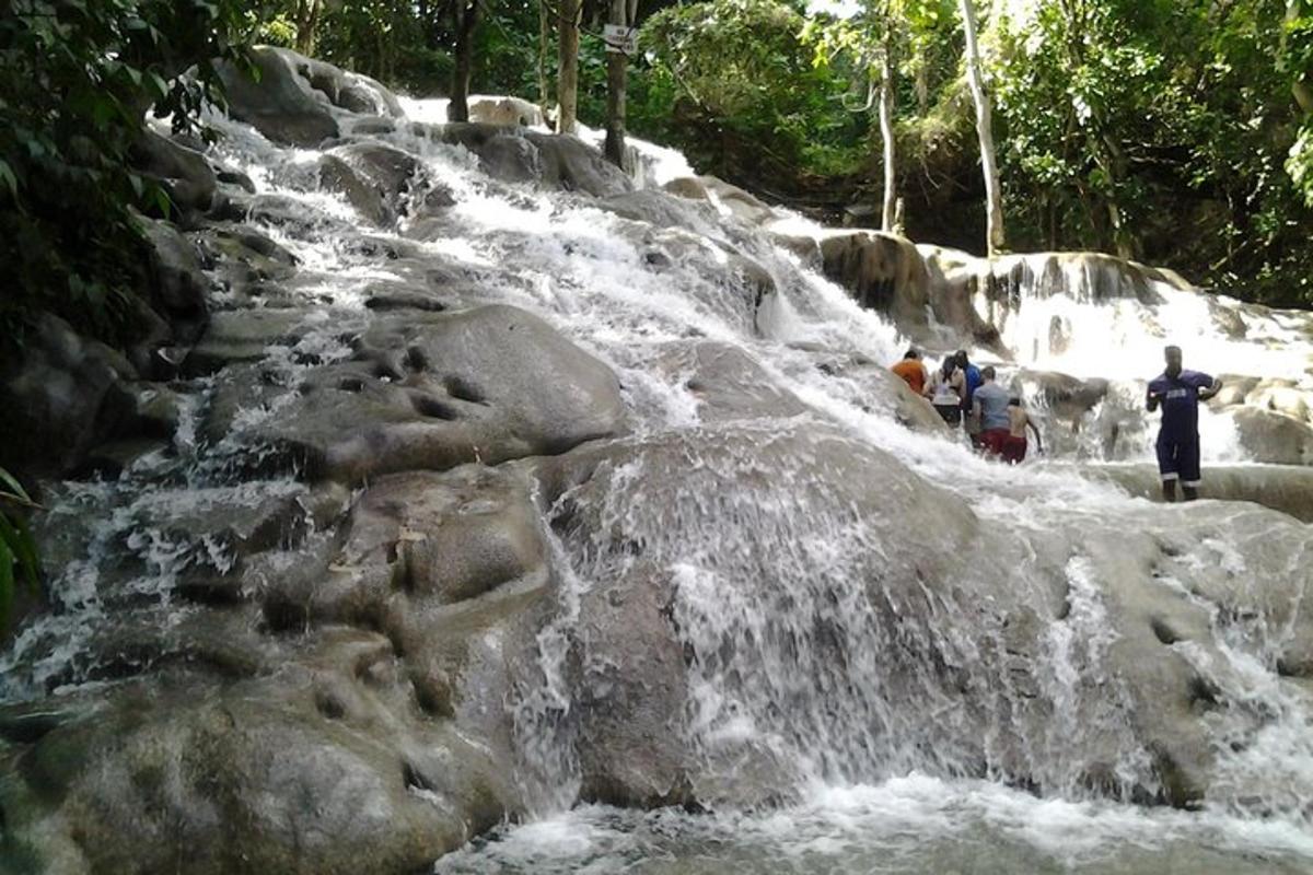 um homem parado em frente a uma cachoeira