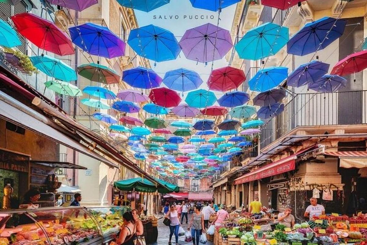 Un mercado con sombrillas de colores colgando del techo.