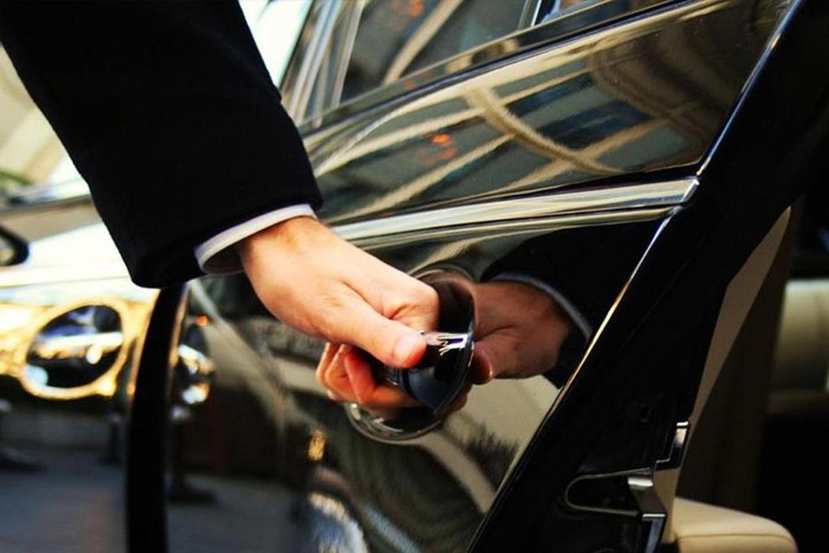 seseorang membuka pintu kereta dengan telefon bimbit