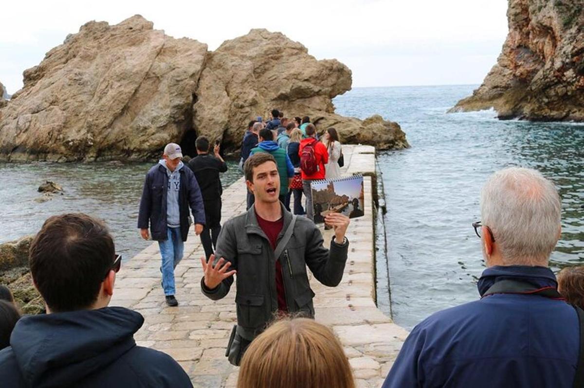 Ένας άντρας στέκεται μπροστά σε μια ομάδα ανθρώπων στην παραλία