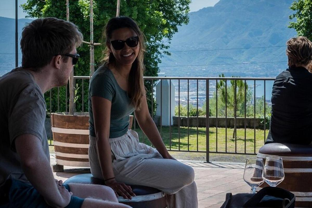 Maður og kona sitja á bekk með vínglösum