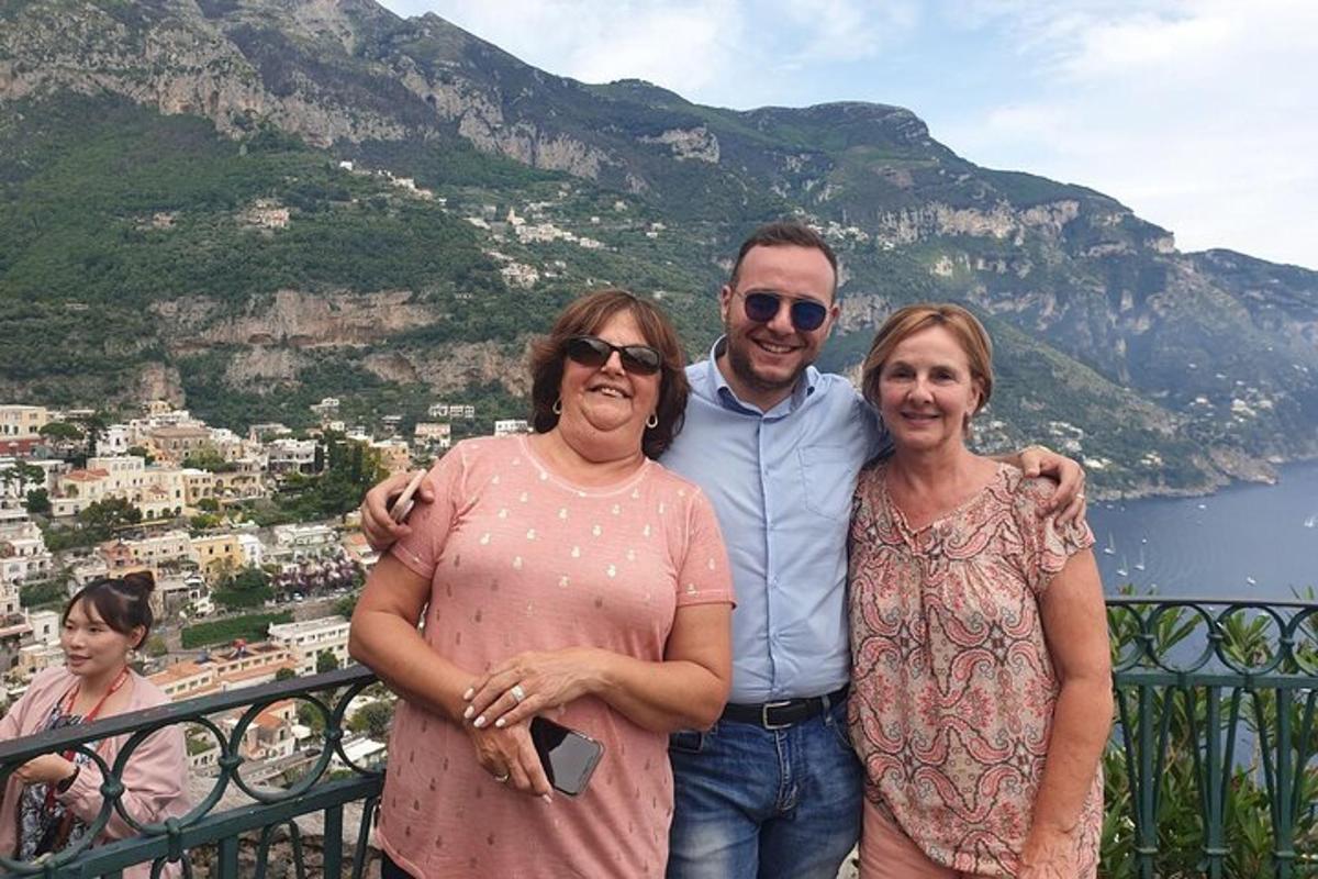 ein Mann und zwei Frauen posieren für ein Foto auf einem Balkon