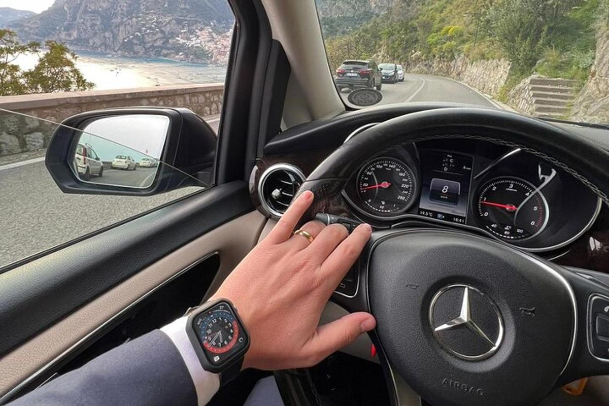 žena řídící auto s rukou na volantu