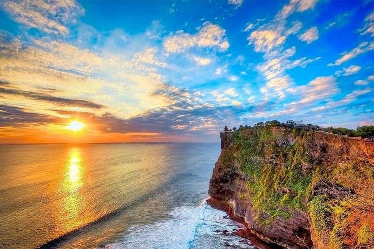 un tramonto sull'oceano accanto a una scogliera