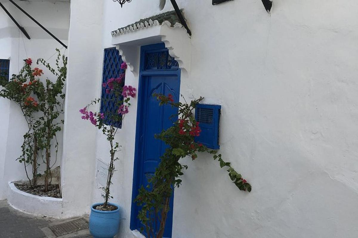 una porta blu su un edificio bianco con fiori