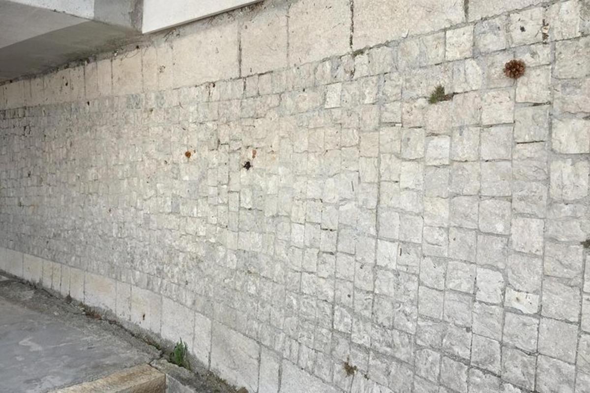 um muro de tijolos brancos ao lado de uma rua