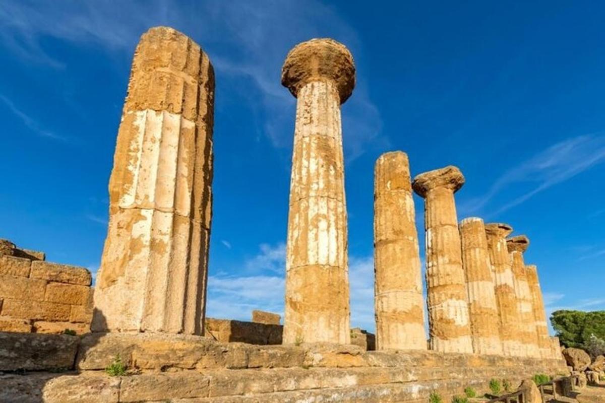 Un antiguo templo con columnas y un cielo azul.