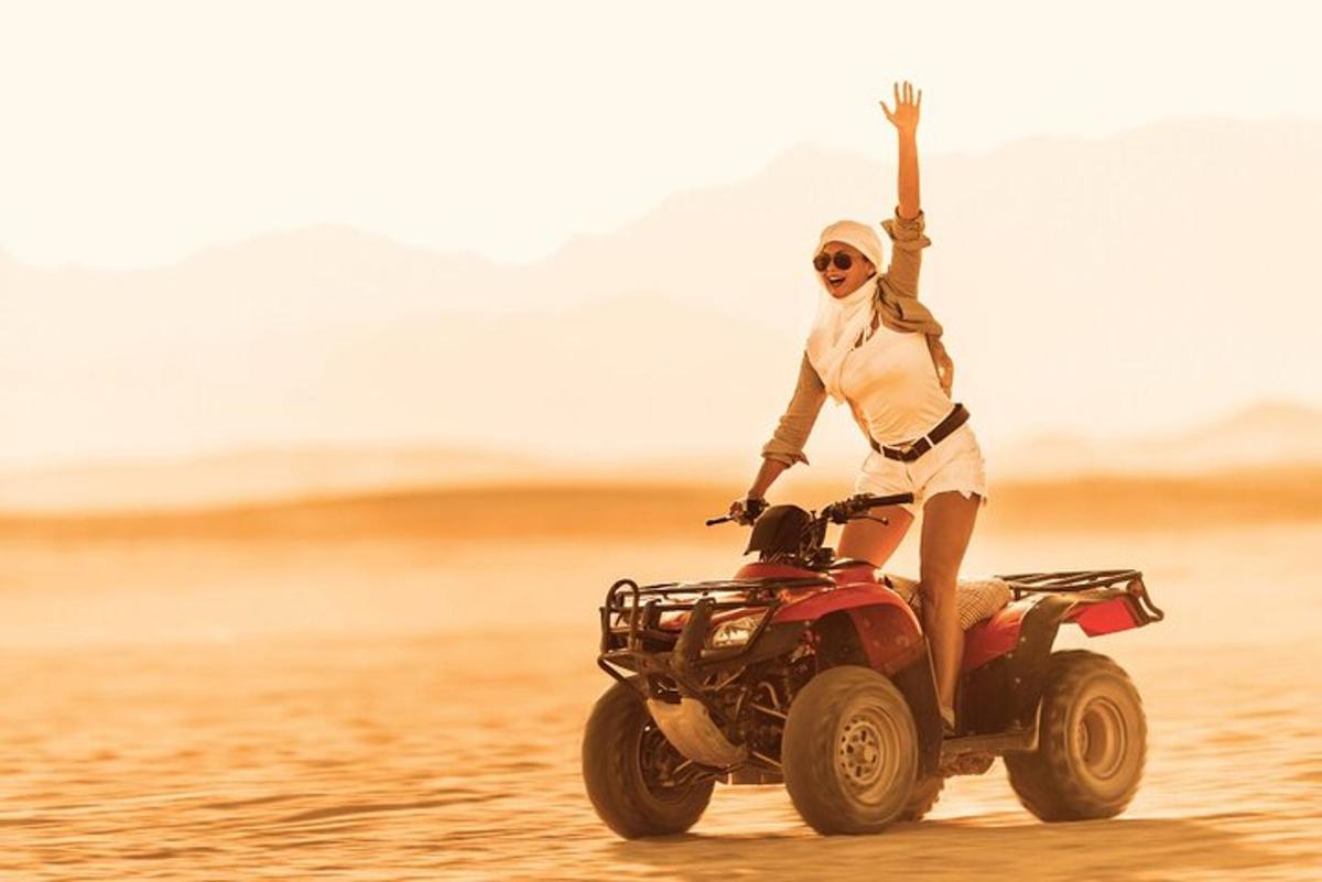 seorang wanita menunggang basikal quad di padang pasir