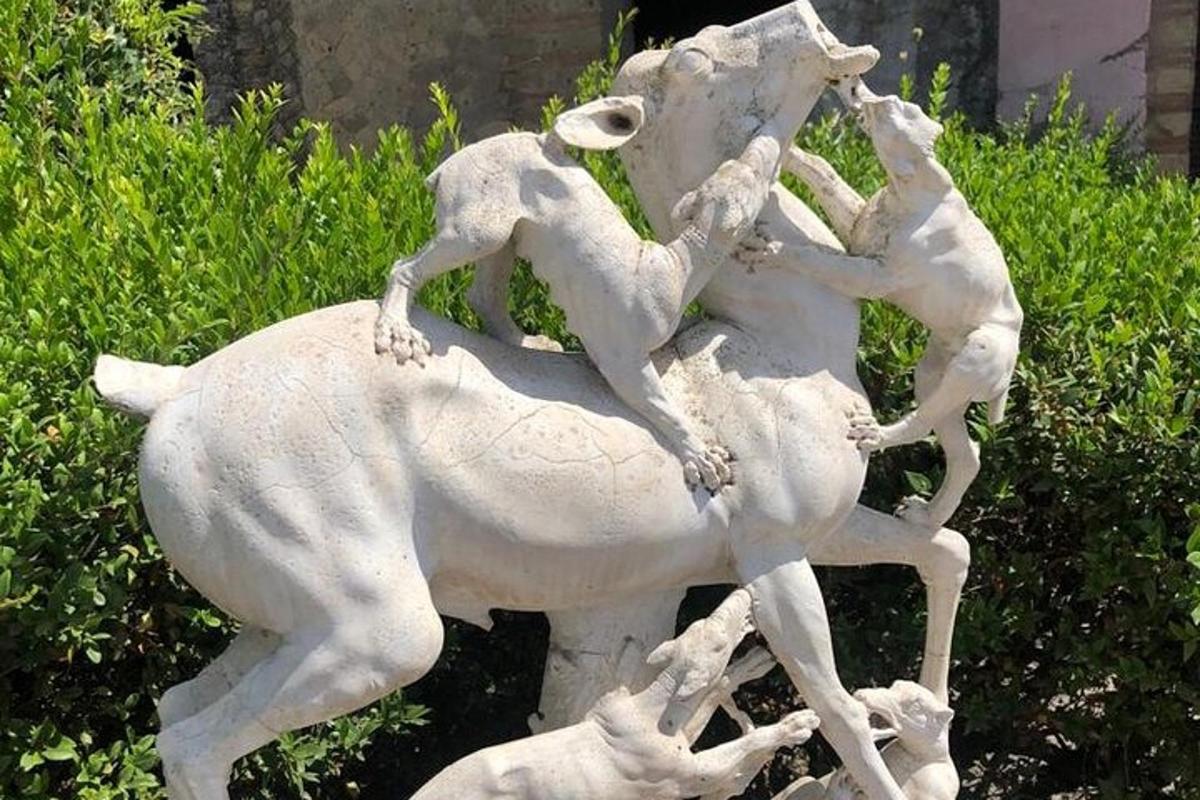 en statue av tre personer som rir på en hest