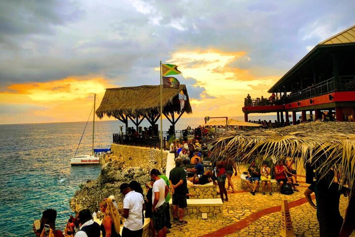 skupina ljudi, ki stojijo na plaži blizu oceana