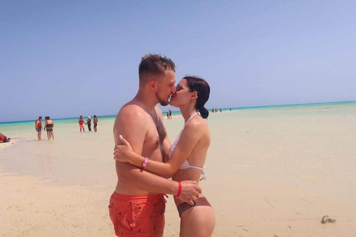 un hombre y una mujer besándose en la playa