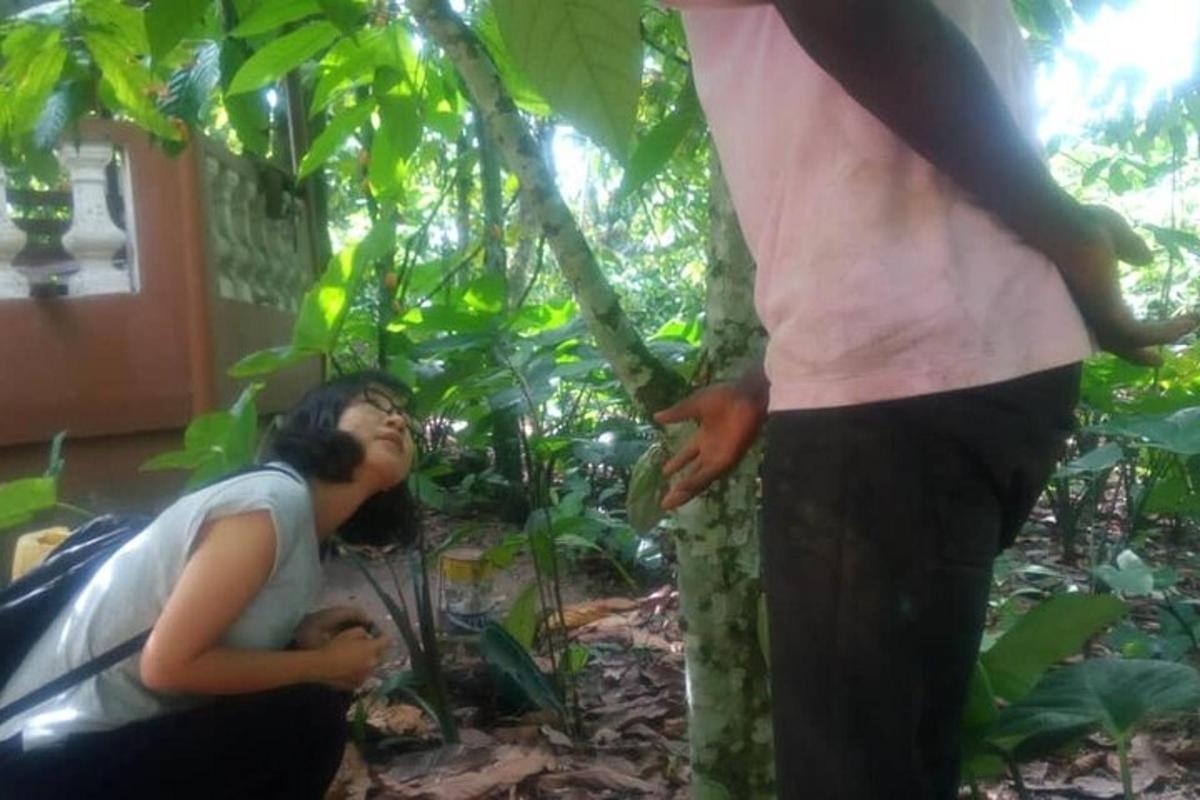 a man looking up at a man standing next to a tree
