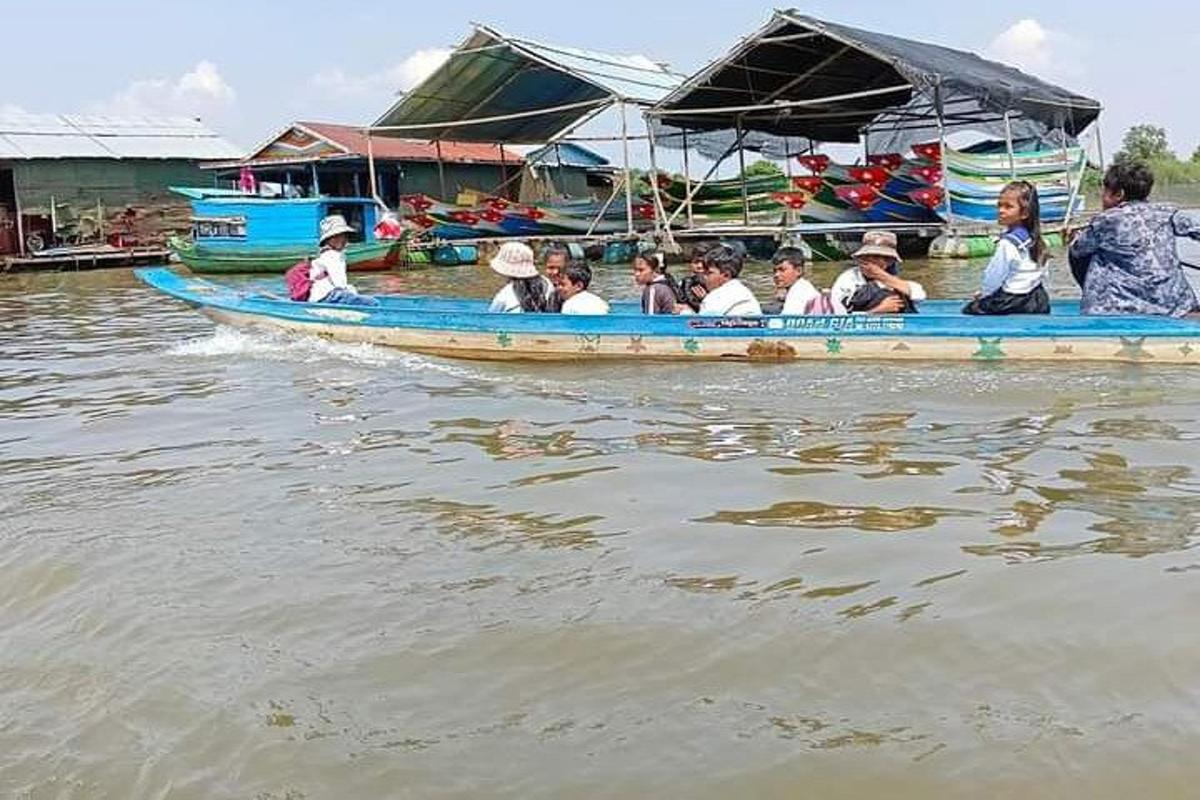 un gruppo di persone su una barca blu sull'acqua