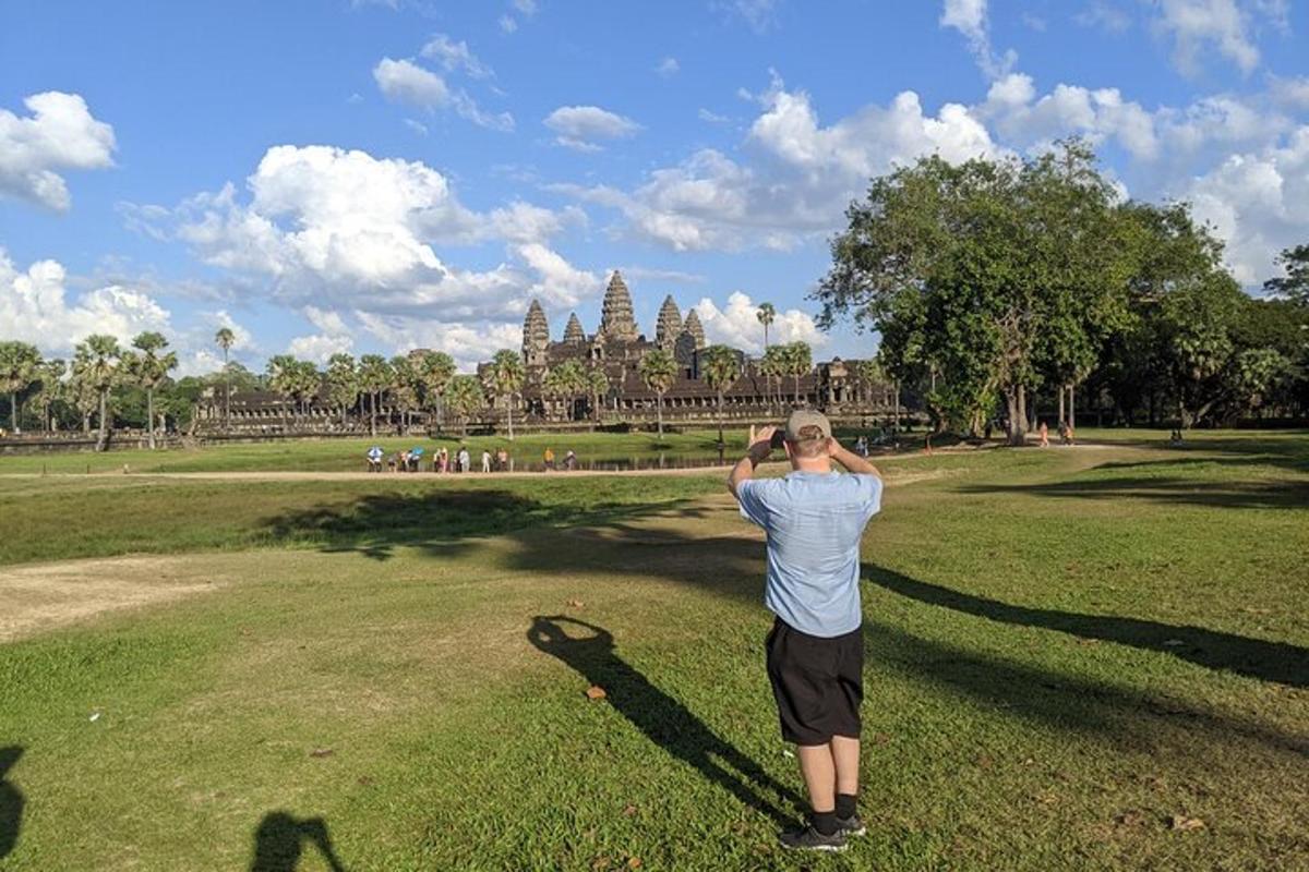 un uomo che scatta una foto di un tempio in un parco
