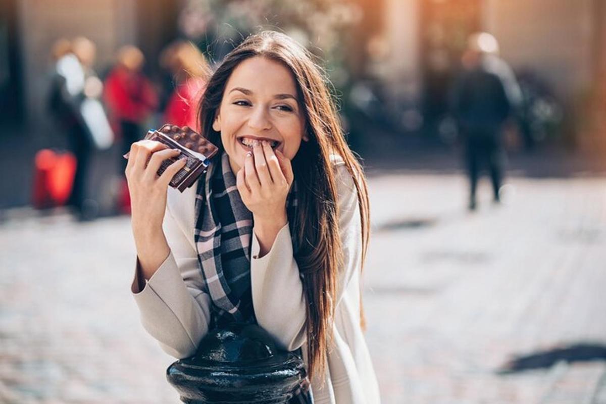 a woman is eating a doughnut on a street