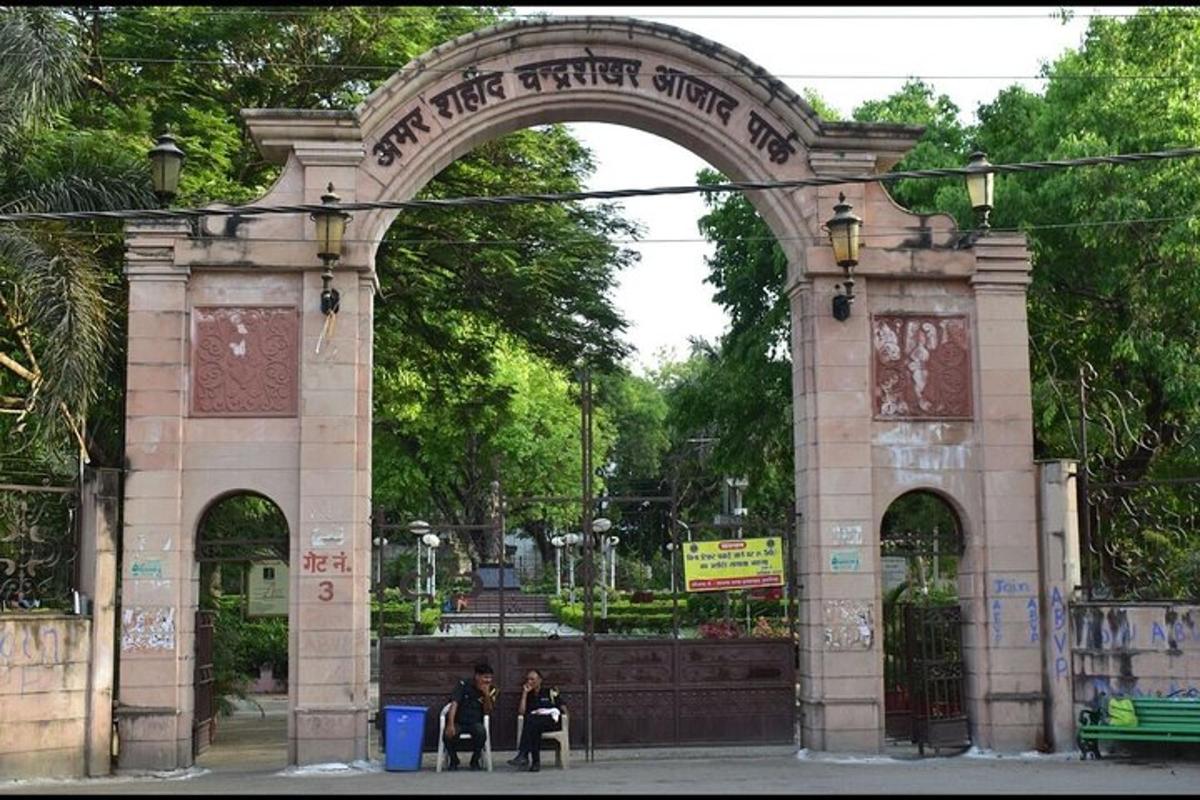 an archway in a park with two people walking through it