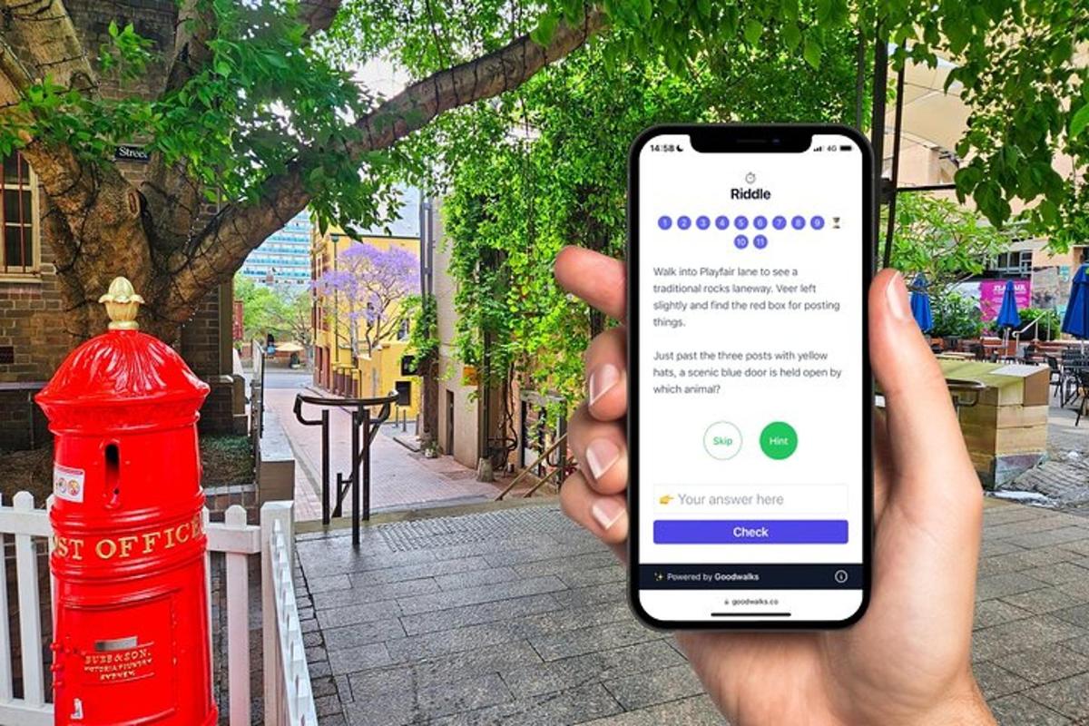 osoba držící mobilní telefon před červeným sloupem