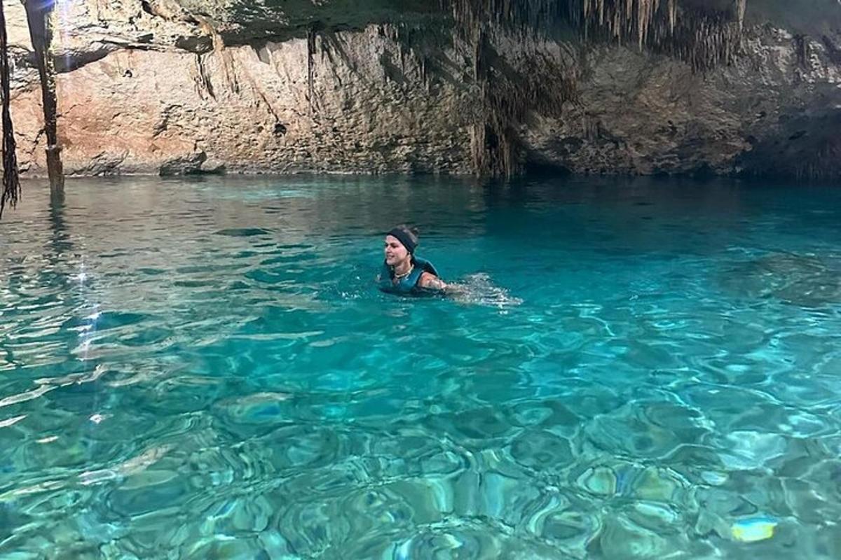 Μια γυναίκα κολυμπάει στο νερό κοντά σε μια σπηλιά