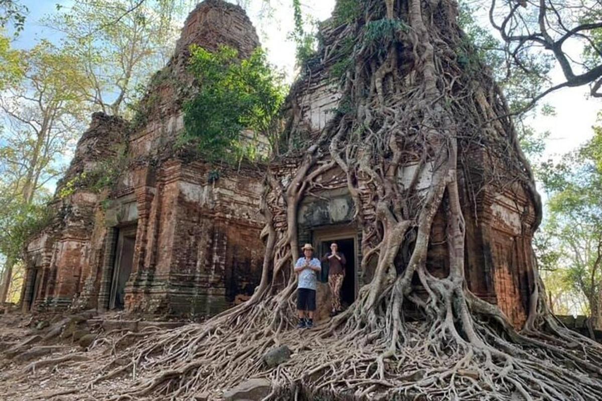 hai người đứng trước một tòa nhà có rễ cây
