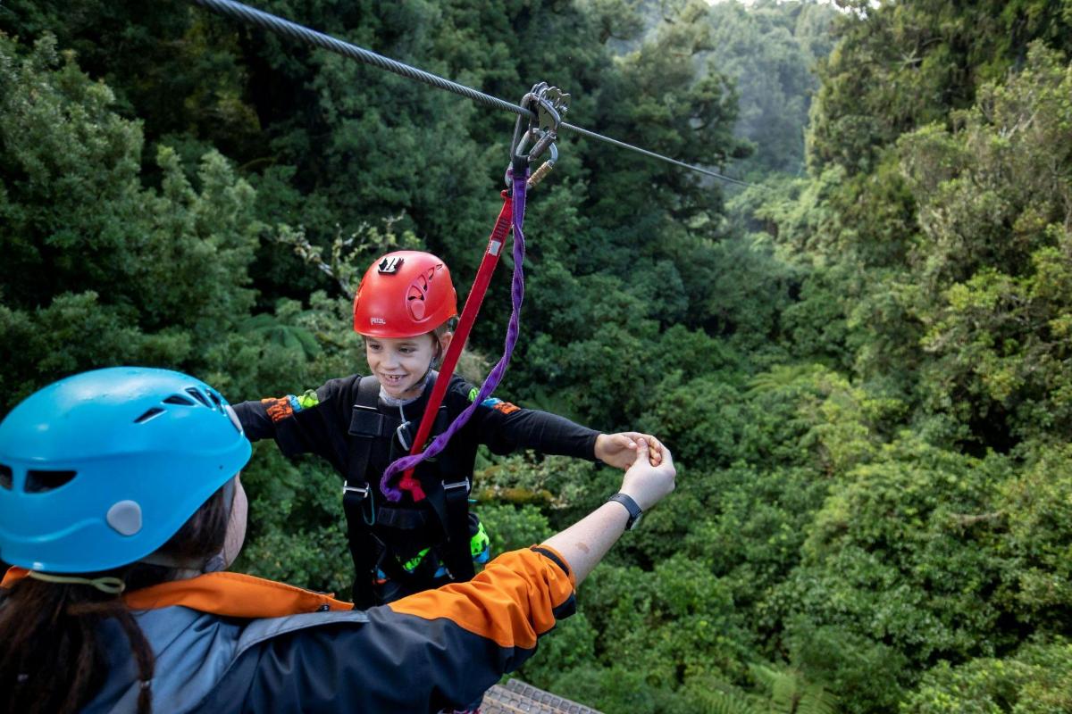 a young girl is on a zip line