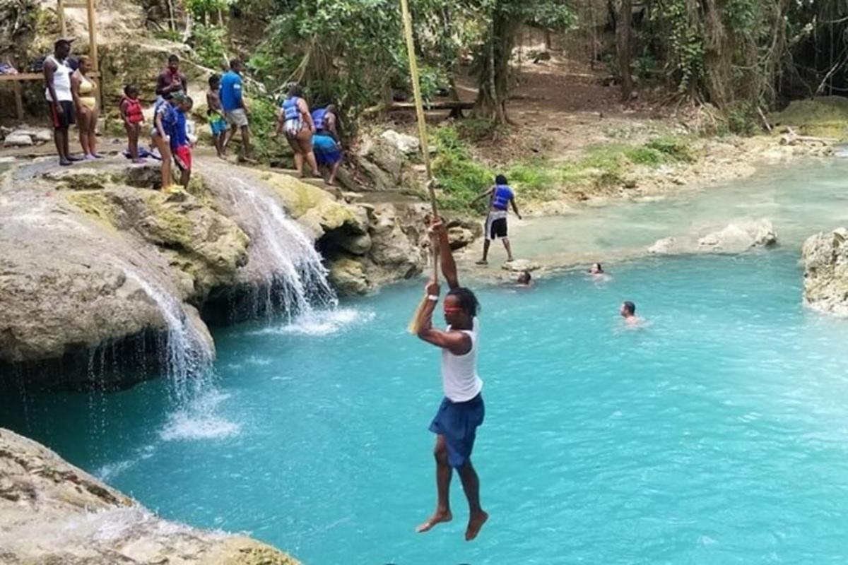 un home està saltant a una cascada d'un riu