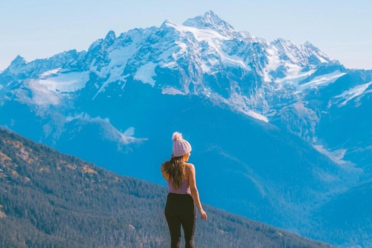 seorang wanita berdiri di atas gunung melihat tasik biru