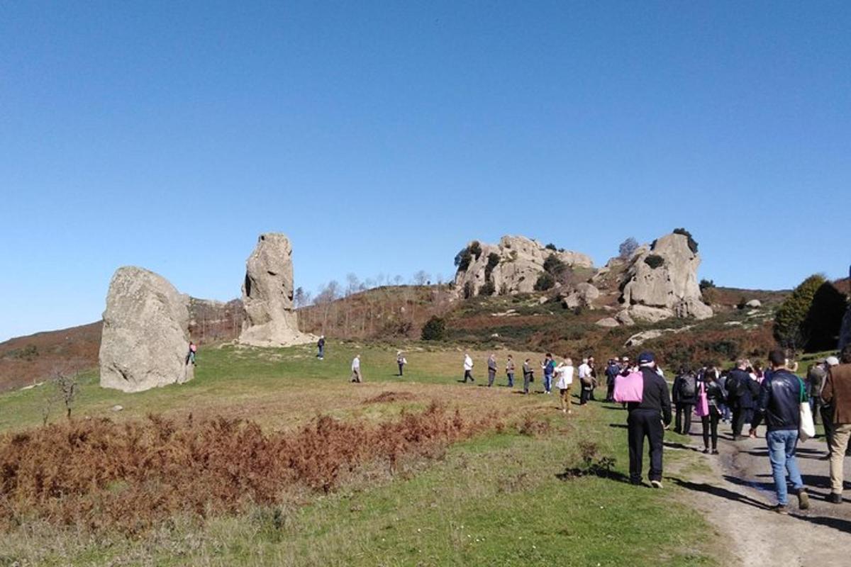 a group of people walking on a path near rocks