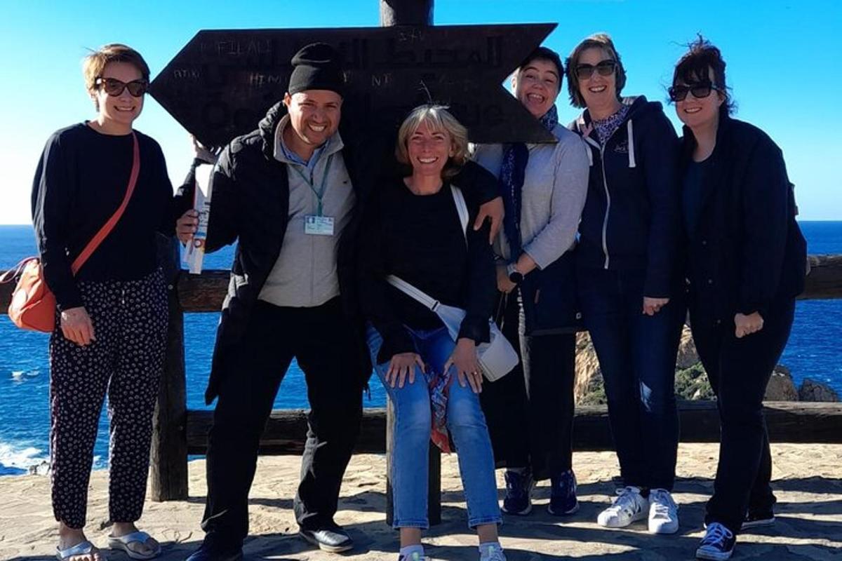 a group of people posing for a picture on the beach